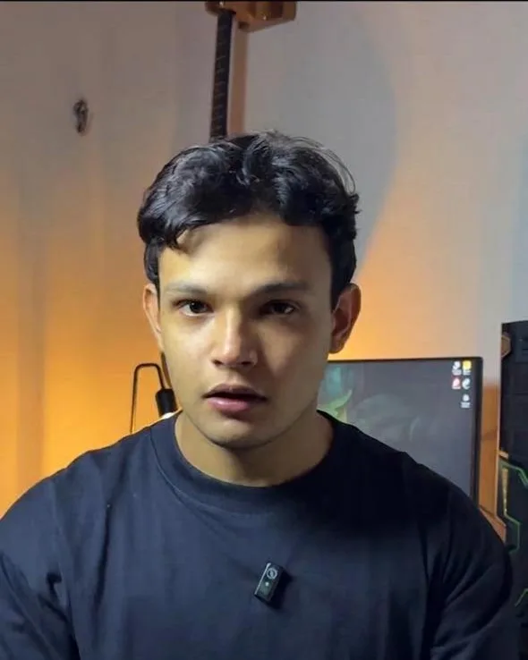 Gabriel gravando conteúdo no estúdio em casa: microfone, monitor e violão ao fundo